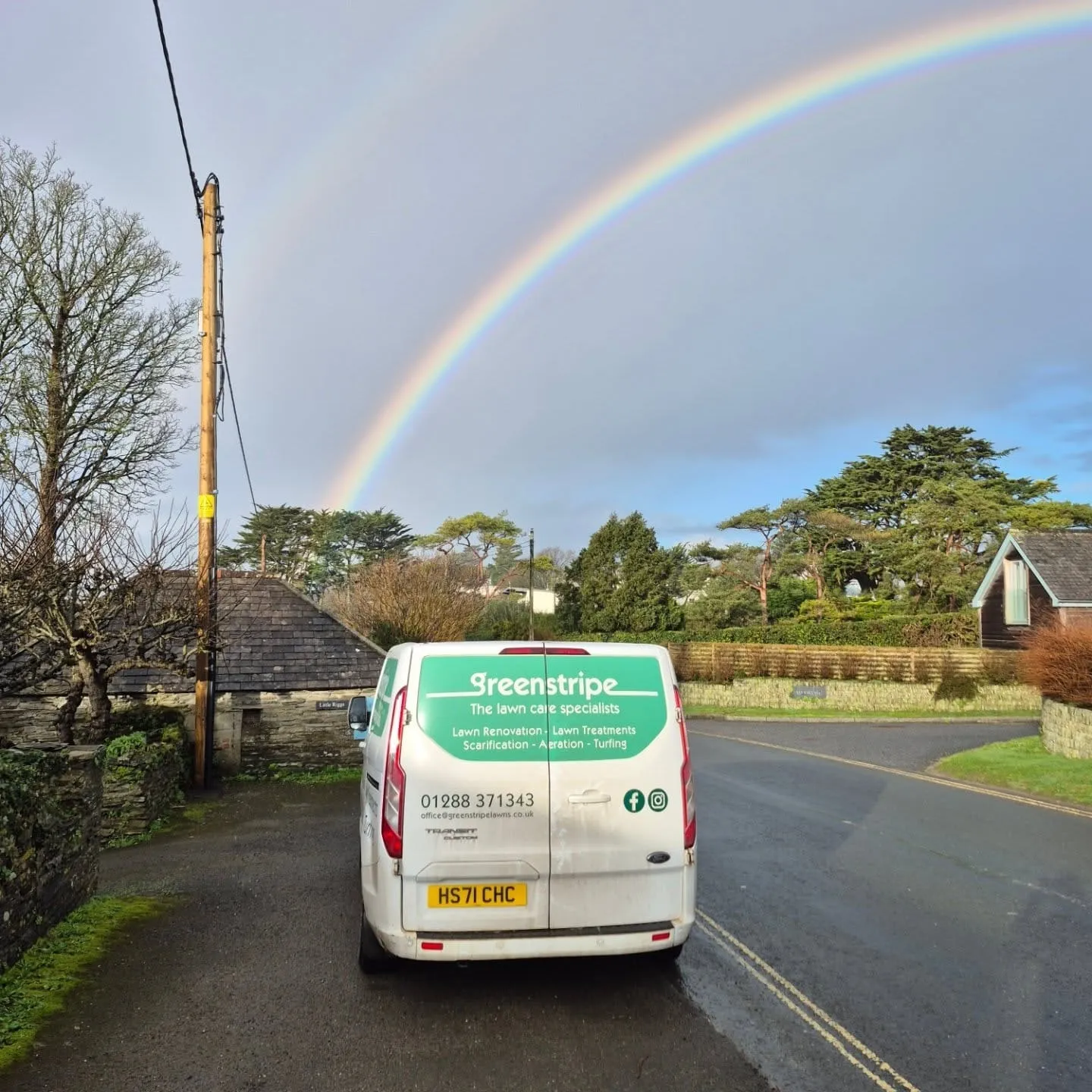 Green Stripe van under a rainbow in the Cornwall countryside